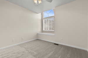 Unfurnished room featuring light colored carpet and ceiling fan