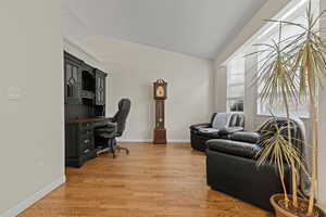 Office space featuring lofted ceiling and light wood finished floors