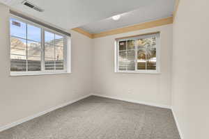 Unfurnished room with light colored carpet, plenty of natural light, and a mountain view