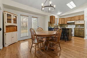 Dining room with a chandelier, lofted ceiling, and light wood-style floors