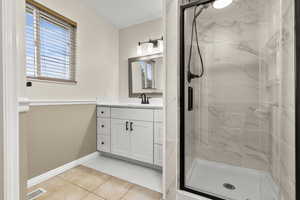 Full bath with vanity, a stall shower, light tile patterned floors, and plenty of natural light