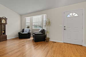 Entryway featuring light wood-type flooring and lofted ceiling