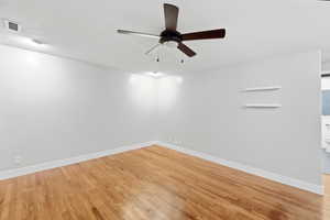 Empty room with light wood-style floors and ceiling fan