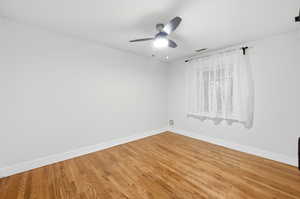Empty room with wood finished floors and ceiling fan