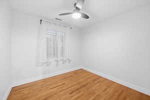 Unfurnished room featuring wood finished floors and a ceiling fan