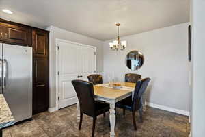 Dining room with a chandelier and stone finish floors