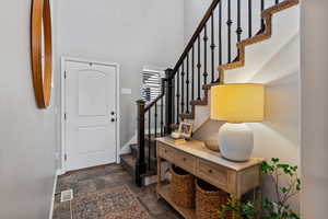 Entrance foyer featuring a high ceiling and dark stone finish flooring