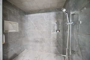 Bathroom featuring tiled shower primary.