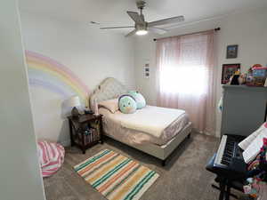 Carpeted bedroom featuring baseboards and ceiling fan