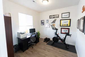 Office with light wood-type flooring and baseboards