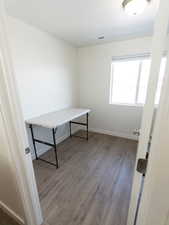 Unfurnished office with light wood-style flooring and baseboards
