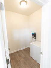 Laundry area featuring light wood-style flooring and baseboards