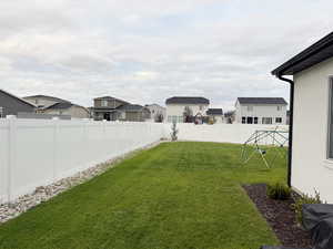 Fenced backyard featuring a residential view
