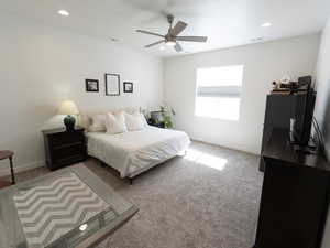 Bedroom with light carpet, ceiling fan, and recessed lighting
