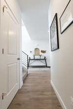 Corridor with light wood-style floors and stairs