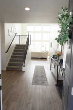 Stairway featuring plenty of natural light, wood finished floors, and recessed lighting