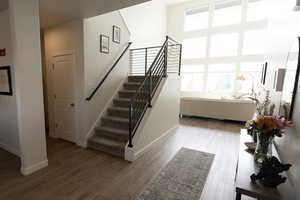 Staircase with a high ceiling and wood finished floors