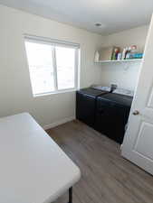 Laundry room with light wood finished floors and washer and clothes dryer
