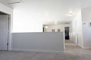 Spare room featuring light colored carpet and baseboards