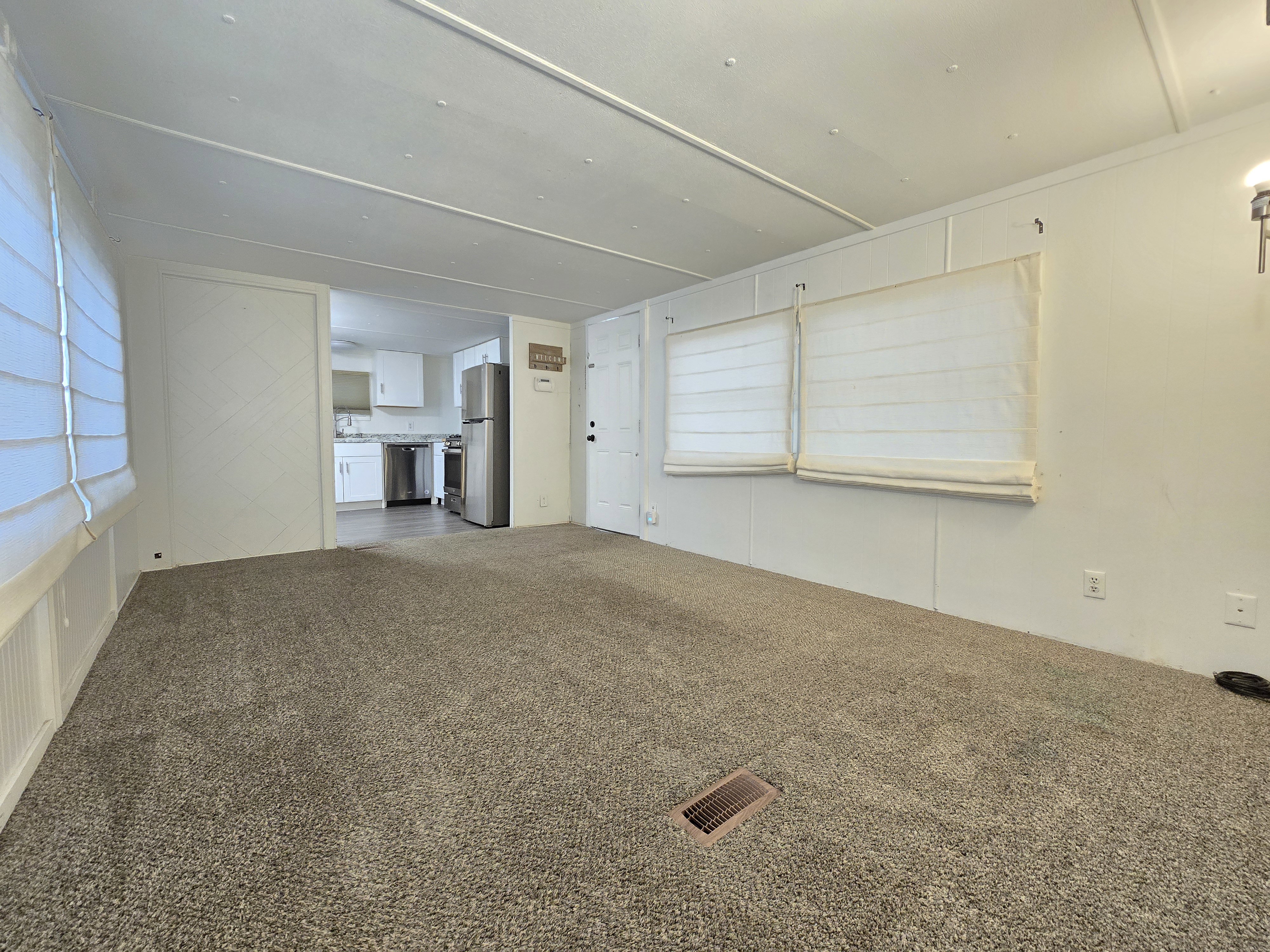 Spacious room featuring neutral carpeting and white wall finishes