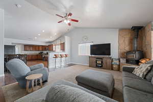 Living room with a ceiling fan, a wood stove, and recessed lighting