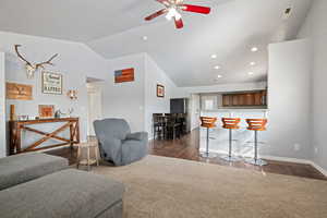 Living room with vaulted ceiling, dark wood-style flooring, ceiling fan, and recessed lighting