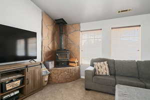 Living room with a wood stove and carpet flooring