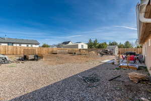 Fenced backyard featuring a shed and a patio