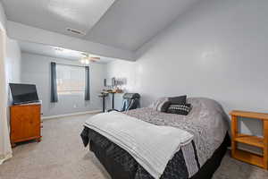 Bedroom with light colored carpet, a ceiling fan, and lofted ceiling