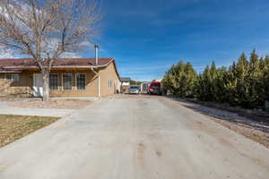 View of property exterior with stucco siding and concrete driveway