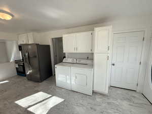 Laundry area featuring light marble finish flooring and independent washer and dryer
