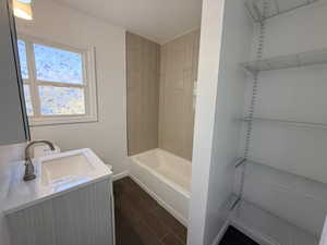 Bathroom with vanity, dark wood-type flooring, and shower / washtub combination