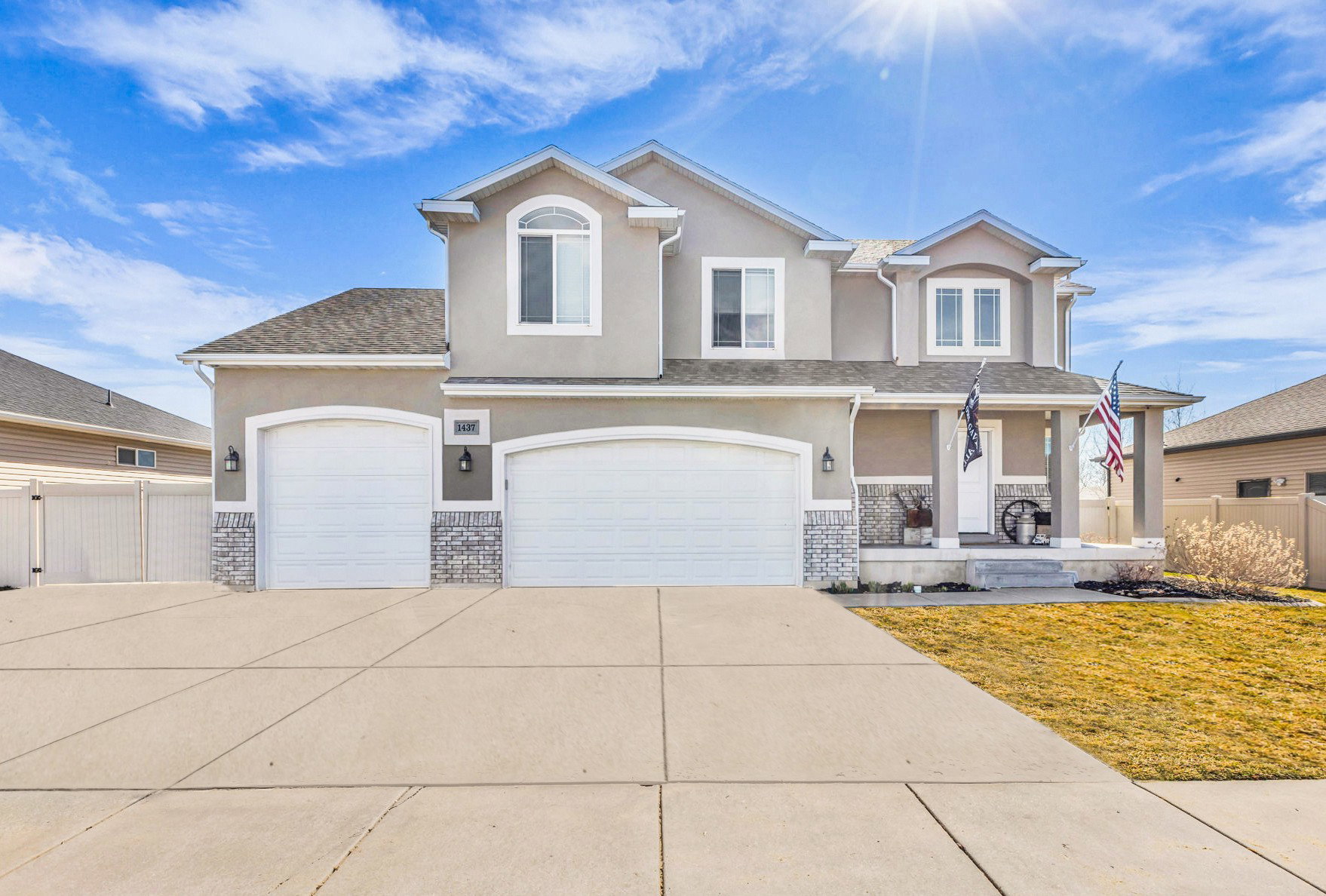 View of front of house with stucco siding, covered porch, concrete driveway, and a garage