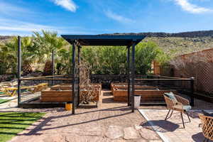 Fenced backyard featuring a vegetable garden and a patio area