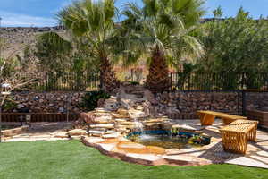 View of yard featuring a garden pond and a patio area