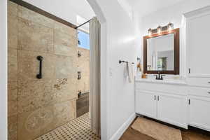 Full bath featuring vanity and a tile shower