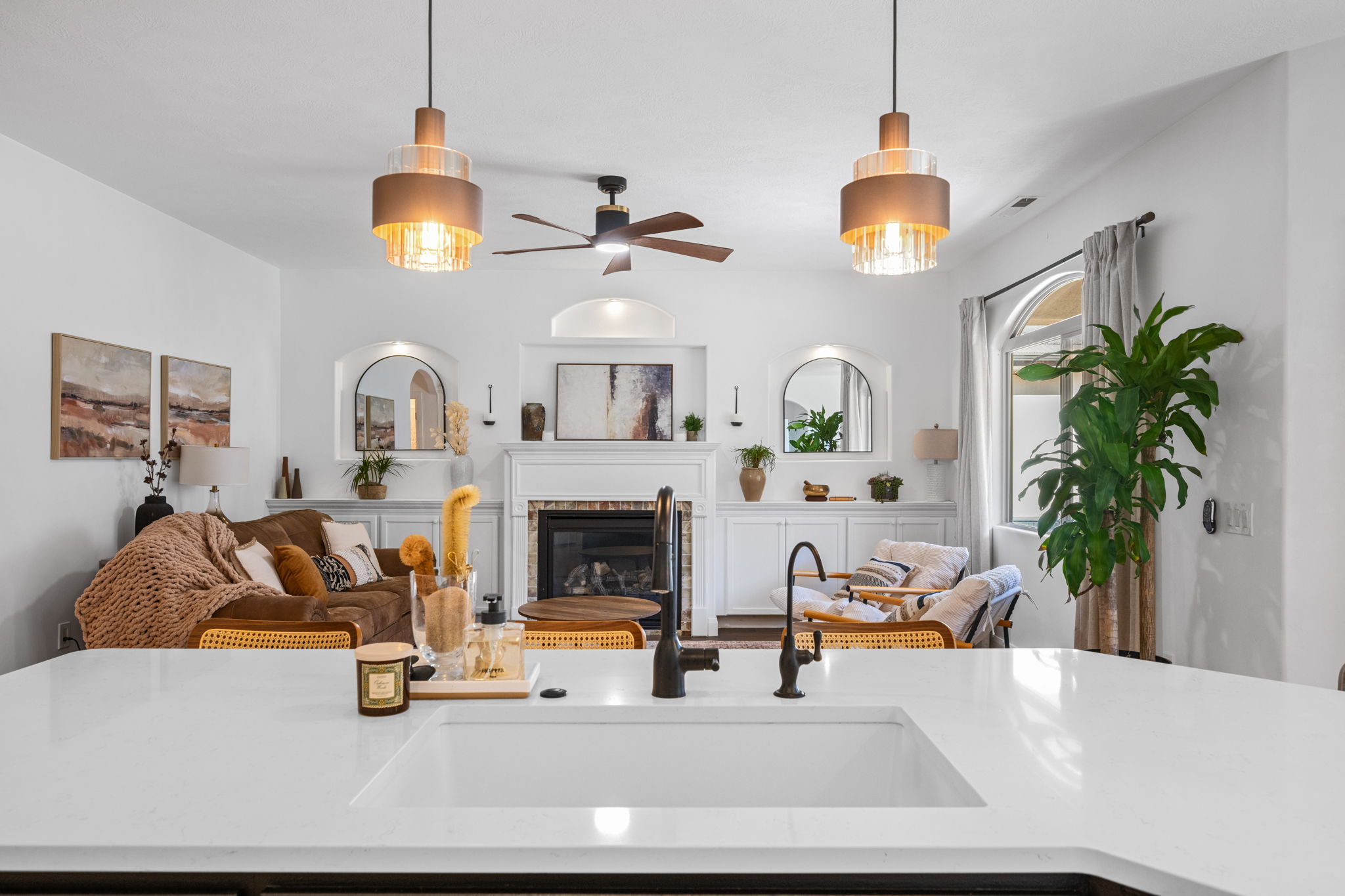 Living area featuring a glass covered fireplace and a ceiling fan