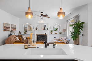 Living area featuring a glass covered fireplace and a ceiling fan