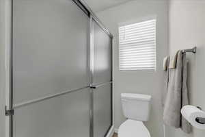 Bathroom featuring a stall shower and toilet