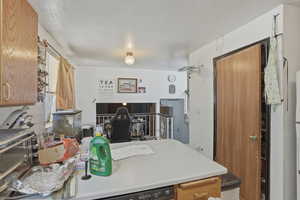 Kitchen with a textured ceiling, light countertops, and wood finish cabinetry