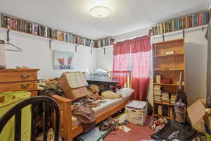 Bedroom with a textured ceiling and carpet flooring