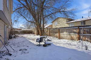 Yard covered in snow featuring a fenced backyard