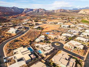 Aerial view of property and surrounding area featuring nearby suburban area and a mountainous background