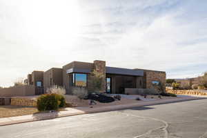Pueblo revival-style home with stucco siding and stone siding