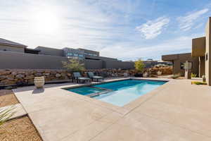 Integrated pool / hot tub featuring a fenced backyard and a patio area