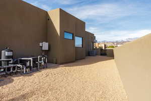 Rear view of house with stucco siding and a mountain view