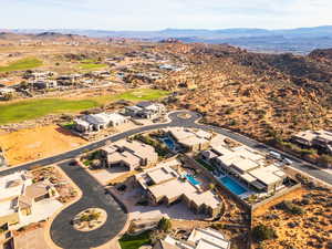 Aerial perspective of suburban area with a mountain backdrop and a local golf course
