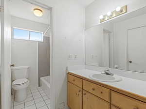 Full bathroom with vanity, light tile patterned floors, and tub / shower combination