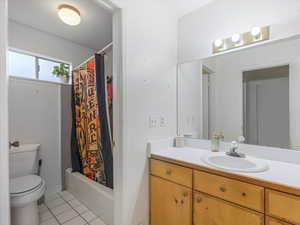 Bathroom featuring vanity, light tile patterned floors, and shower / bath combo