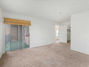 Unfurnished room featuring light carpet and baseboards